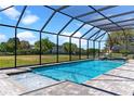 Relaxing screened-in pool and spa with brick pavers, perfect for enjoying sunny days in a private oasis at 14823 Borromini St, Montverde, FL 34756