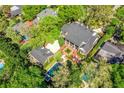 Aerial view of a lush estate featuring a main house, a separate structure, a pool, and manicured landscaping at 1911 Stonehurst Rd, Winter Park, FL 32789