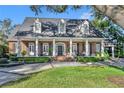 Charming brick home featuring a welcoming front porch with classic columns and a beautifully landscaped front yard at 1911 Stonehurst Rd, Winter Park, FL 32789