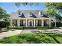 Beautiful home with classic architecture, including dormer windows, columns and a manicured lawn at 1911 Stonehurst Rd, Winter Park, FL 32789
