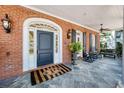 Inviting front porch with rocking chairs, a decorative rug, and classic brick facade at 1911 Stonehurst Rd, Winter Park, FL 32789