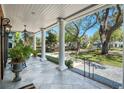 Covered porch featuring pillars, outdoor furniture, and a view of the landscaped front yard at 1911 Stonehurst Rd, Winter Park, FL 32789