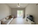 Bright living room with wood floors, a comfortable couch, and a sliding door to a balcony at 1972 Lake Atriums Cir # 200, Orlando, FL 32839