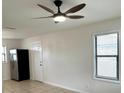 The living room includes a modern ceiling fan, a stainless refrigerator and a window at 214 Lucile Way, Orlando, FL 32835