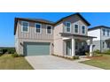 Well-kept two-story home with a teal garage door, a cozy front porch and a manicured lawn at 2342 Gold Dust Dr, Minneola, FL 34715