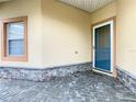 Cozy front porch area with stone accents, neutral paint, brick pavers, and window offering natural light at 253 Lake Cassidy Dr, Kissimmee, FL 34759