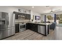 A modern kitchen features stainless steel appliances, granite countertops, and dark cabinetry that enhances the space at 2537 Renshaw St, Kissimmee, FL 34747