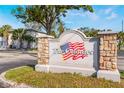 Entrance to The Colonies community showcasing the stone sign and American flag logo on a sunny day at 3071 George Mason Ave # 5, Winter Park, FL 32792