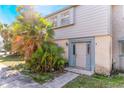 A townhouse with a well-kept front yard, featuring lush foliage and a light-colored exterior at 3071 George Mason Ave # 5, Winter Park, FL 32792