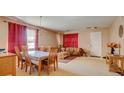 Formal living room with dining table and chairs, carpeted floors, and decorative red curtains at 368 Sand Ridge Dr, Davenport, FL 33896