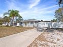 Inviting single-story home featuring a long driveway and a vibrant yellow front door with manicured landscape at 3764 Pinehurst St, Deltona, FL 32738