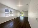 Bright living room featuring wood floors, ample natural light, and seamless access to the backyard at 3882 Crawley Down Loop, Sanford, FL 32773