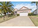 Inviting home with a two-car garage, long driveway, well manicured lawn and tropical landscaping at 4724 Sable Ridge Ct, Leesburg, FL 34748