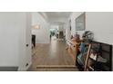 Open hallway with wood-look flooring and modern decor, leading to various rooms within the home at 4796 Riverwalk Dr, St Cloud, FL 34771