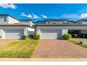 Townhome garages showing brick driveways and tidy landscaping, great parking solution at 5814 Bimini Twist Loop, Orlando, FL 32819