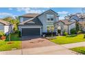 Charming two-story home featuring a well-manicured lawn, brick driveway, and attached two-car garage at 753 Daybreak Pl, Longwood, FL 32750