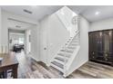 Bright foyer features wood-look flooring, a staircase with white railing, and a stylish decorative clock at 8066 Bowery Dr, Winter Garden, FL 34787