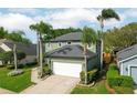 Charming two-story residence with a two-car garage, complemented by palm trees and a neatly kept lawn at 9400 Southern Garden Cir, Altamonte Springs, FL 32714