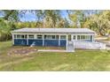 Close up exterior of a blue house, showcasing large windows and a ramp for easy accessibility at 10115 E Highway 316, Fort Mc Coy, FL 32134