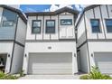 The front of a town house with a gray two-car garage and a gray stone driveway at 10443 Ebb Tide Ln, Orlando, FL 32821