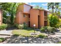 Exterior view of a two-story condo with mature landscaping and a well-maintained lawn at 1068 E Michigan St # A, Orlando, FL 32806