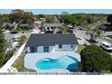 Aerial view showcasing a kidney-shaped pool surrounded by a gray concrete patio and a white fence at 11364 Cardiff Dr, Orlando, FL 32837