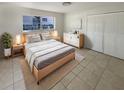 Cozy bedroom features a large bed, natural light, and a minimalist aesthetic with light wood furniture at 1155 Galahad Dr, Casselberry, FL 32707