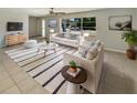 Bright living room featuring white sofas, striped rug, and ample natural light from a large window at 1155 Galahad Dr, Casselberry, FL 32707