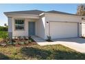 A charming house exterior featuring a beautiful lawn, fresh landscaping, and an attached two-car garage at 13820 Adams St, Grand Island, FL 32735