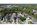 Aerial view of a quiet neighborhood with two-story homes, mature trees, and a community pond nearby at 1421 Arbitus Cir, Oviedo, FL 32765