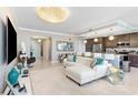 Open living space featuring a white leather couch, stunning chandeliers, and marble floors at 16300 County Road 455 # 401, Montverde, FL 34756