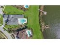 An aerial view of a luxury house and pool, nestled beside a serene lake at 17300 Pesce Loop, Montverde, FL 34756