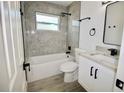 Beautifully remodeled bathroom featuring gray marble-look tile, modern fixtures, and bathtub at 2360 Justy Way, Orlando, FL 32817
