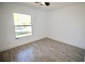 Bright bedroom with stylish gray wood-look tile flooring and a large window for natural light at 2360 Justy Way, Orlando, FL 32817