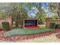 The Eagle Trace community sign features brick pillars, lush greenery, and vibrant red flowers at 2365 Eagle Trace Dr, Kissimmee, FL 34746