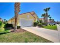 Inviting yellow home with red tile roof, showcasing well-maintained landscaping and a two-car garage at 248 Rosso Dr, Davenport, FL 33837