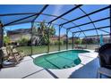 Screened in-ground pool with outdoor furniture, BBQ, and lush landscaping creating a private backyard oasis at 248 Rosso Dr, Davenport, FL 33837