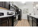 Modern kitchen featuring dark cabinets, stainless steel appliances, and light countertops at 2774 Almaton Loop # 403, Kissimmee, FL 34747