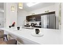 Stylish kitchen bar with modern stools, quartz countertops, and stainless steel appliances at 2774 Almaton Loop # 403, Kissimmee, FL 34747
