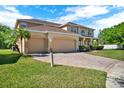 Charming two-story home with a three-car garage, brick-paved driveway, and lush landscaping at 4393 S Devon Ct, Kissimmee, FL 34746