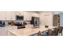 Modern kitchen featuring stainless steel appliances, white cabinets, and a large center island at 4839 Sunflower St, Lake Hamilton, FL 33851
