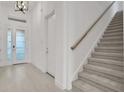 Bright entryway features a staircase, tiled flooring, and a glass-paneled front door at 6239 Woodhaven Village Dr, Port Orange, FL 32128