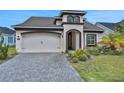 Attractive home with two-car garage, brick-paved driveway and landscaped front yard at 6239 Woodhaven Village Dr, Port Orange, FL 32128