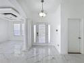 Bright foyer featuring marble floors, modern lighting, and decorative columns at 910 Suffolk Pl, Davenport, FL 33896