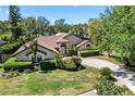 Aerial view of a well-landscaped home with a circular driveway, mature trees, and manicured hedges at 10116 Pointview Ct, Orlando, FL 32836