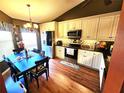 Well-lit kitchen featuring white cabinetry, modern appliances, and a cozy dining area at 109 Lakepointe Cir, Kissimmee, FL 34743