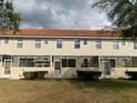 Rear exterior view of townhomes featuring screened-in patios with tile roofs and simple landscaping at 1285 S South Beach Circle Cir, Kissimmee, FL 34746
