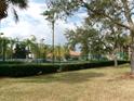 Community tennis court surrounded by fencing, mature trees, and well-kept grounds at 1285 S South Beach Circle Cir, Kissimmee, FL 34746