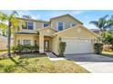 Inviting two-story home with a two-car garage, a well-maintained lawn, and a charming front entrance at 14740 Hartford Run Dr, Orlando, FL 32828