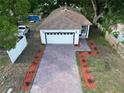A beautiful home with a brick driveway, enhanced by fresh landscaping and a pristine white exterior at 1505 25Th St, Orlando, FL 32805